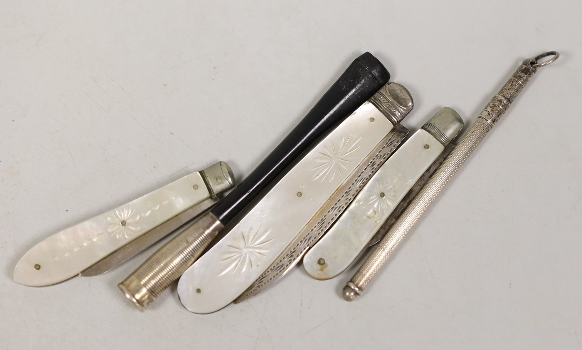 Three assorted mother of pearl mounted silver fruit knives, largest 82mm, a cigarette holder and a swizzle stick.